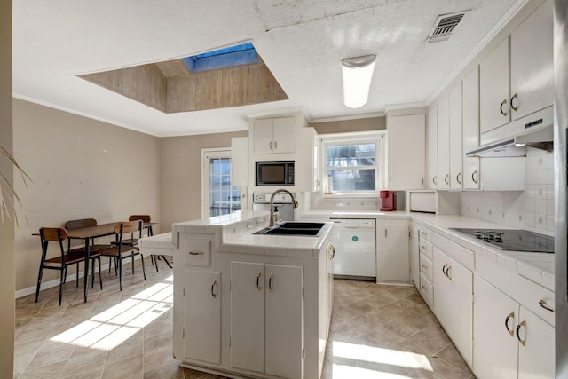 kitchen with sink, white cabinets, black appliances, and a kitchen island with sink