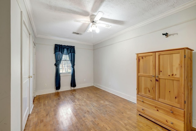 unfurnished bedroom featuring ceiling fan, wood-type flooring, crown molding, and a textured ceiling