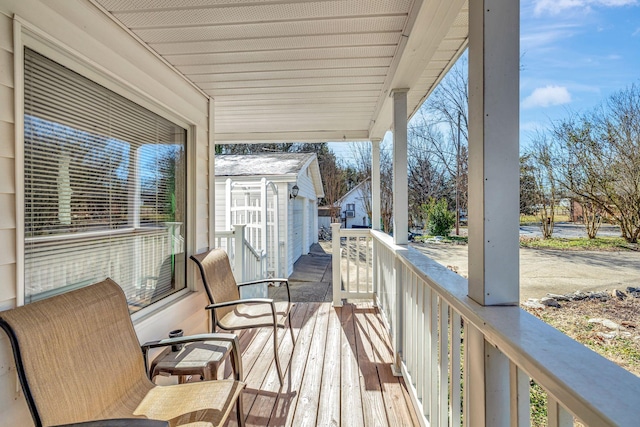 wooden terrace featuring an outdoor structure and a porch