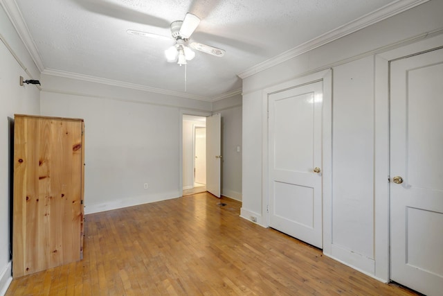 unfurnished bedroom with ceiling fan, a textured ceiling, ornamental molding, and light hardwood / wood-style floors