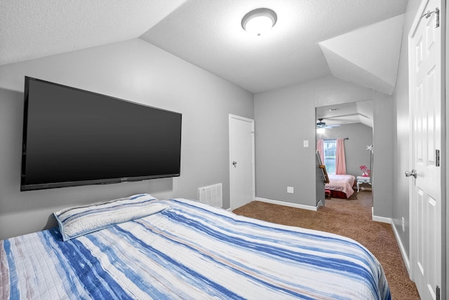 bedroom with carpet, vaulted ceiling, and a textured ceiling