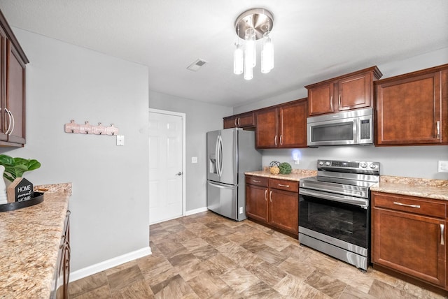 kitchen with light stone countertops and stainless steel appliances