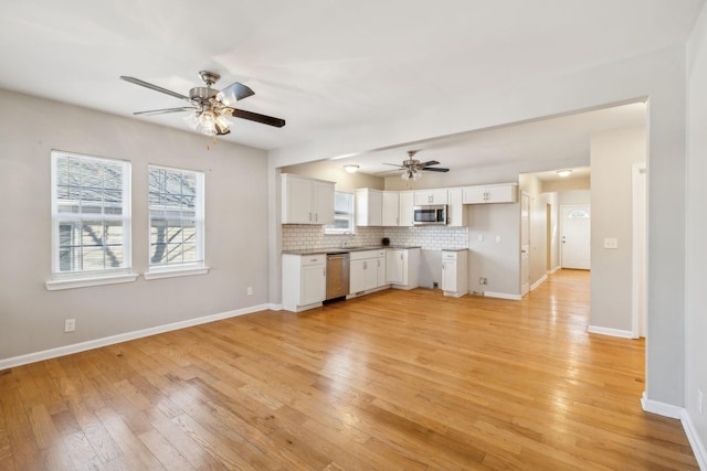 kitchen featuring light hardwood / wood-style floors, ceiling fan, stainless steel appliances, decorative backsplash, and white cabinets