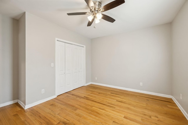 unfurnished bedroom featuring ceiling fan, a closet, and wood-type flooring