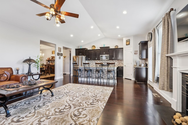 living room featuring ceiling fan, dark hardwood / wood-style floors, and high vaulted ceiling