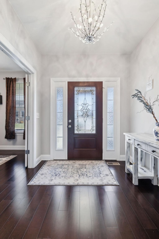 entryway featuring dark hardwood / wood-style flooring and a notable chandelier