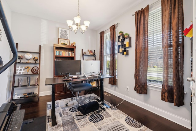 home office featuring dark wood-type flooring and a notable chandelier