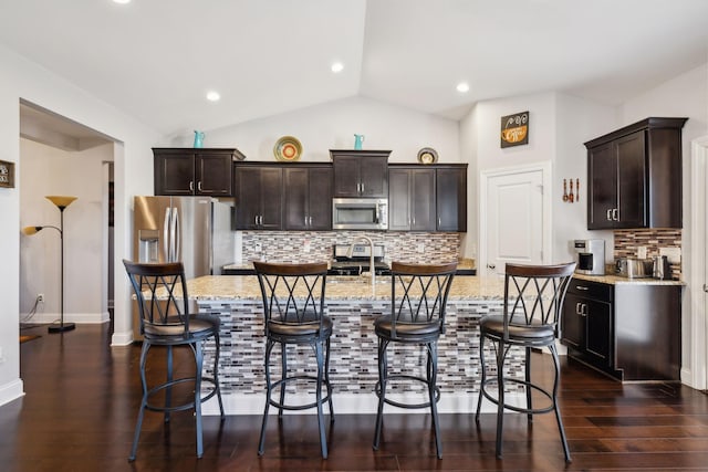 kitchen featuring appliances with stainless steel finishes, decorative backsplash, and light stone countertops