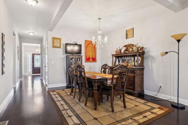 dining room with dark hardwood / wood-style floors and a notable chandelier