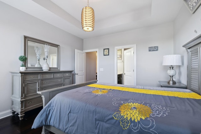 bedroom featuring dark hardwood / wood-style flooring and a tray ceiling