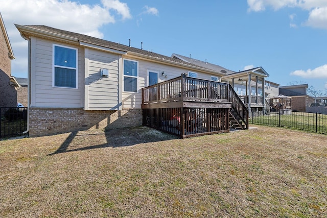 rear view of property with a wooden deck and a yard