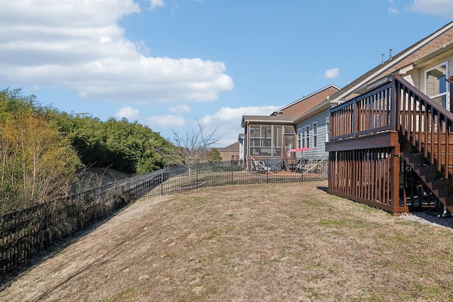 view of yard featuring a wooden deck and a sunroom