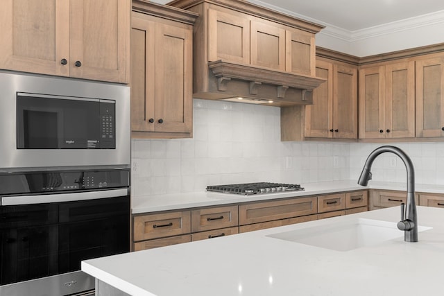 kitchen featuring crown molding, light countertops, decorative backsplash, appliances with stainless steel finishes, and a sink