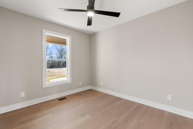 spare room featuring visible vents, ceiling fan, light wood-style flooring, and baseboards