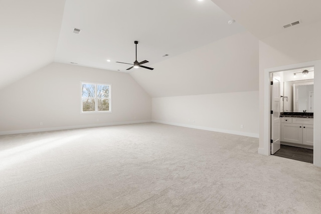 bonus room featuring baseboards, visible vents, vaulted ceiling, and carpet flooring