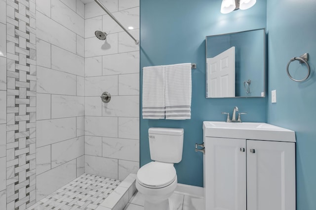 bathroom with tiled shower, vanity, and toilet