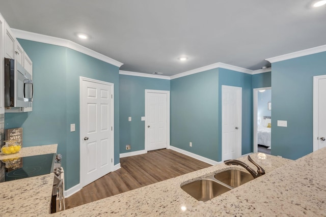 kitchen featuring stainless steel appliances, ornamental molding, white cabinets, and sink