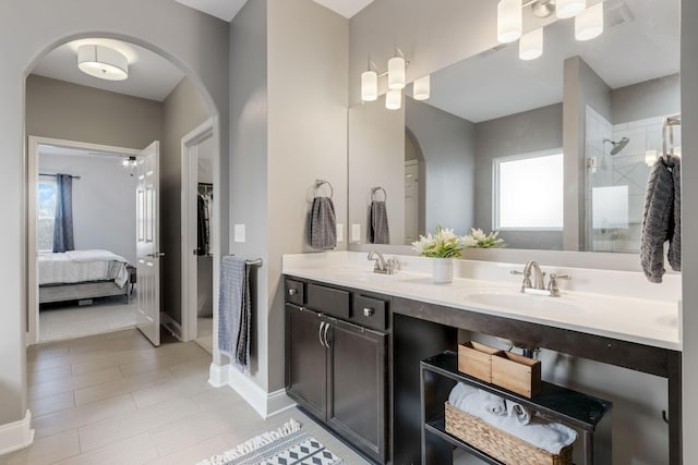 bathroom with tiled shower, a healthy amount of sunlight, and vanity