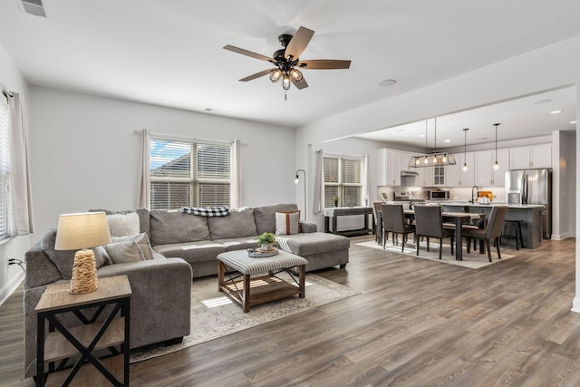 living room with ceiling fan and dark hardwood / wood-style flooring