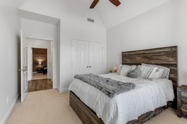 carpeted bedroom featuring high vaulted ceiling, ceiling fan, and a closet