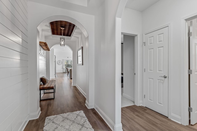 hallway featuring a tray ceiling and dark hardwood / wood-style floors