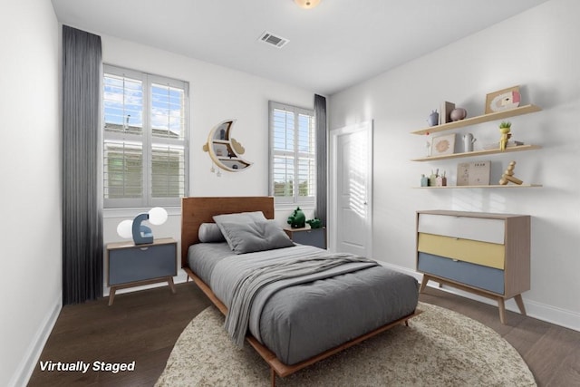 bedroom featuring dark wood-type flooring and multiple windows