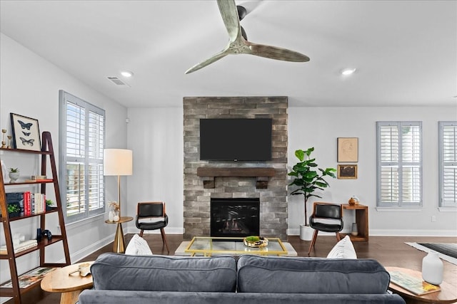 living room with a brick fireplace, a wealth of natural light, hardwood / wood-style flooring, and ceiling fan