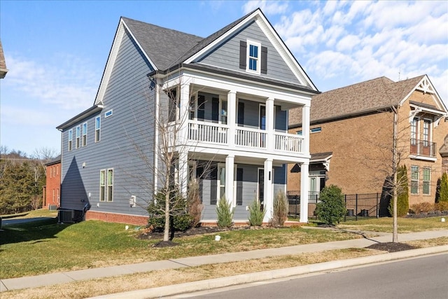 neoclassical home featuring a front lawn, central AC unit, and a balcony