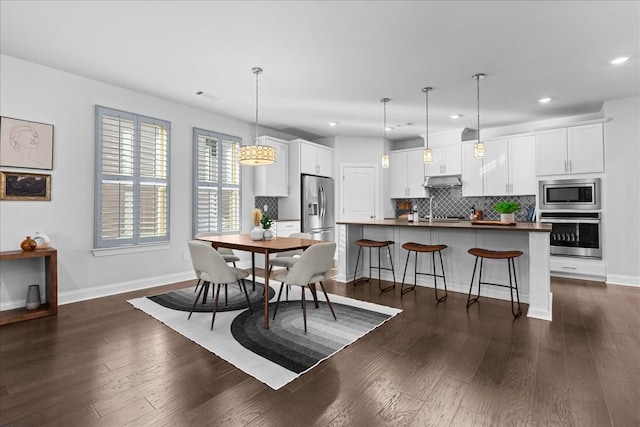 dining space with dark hardwood / wood-style flooring