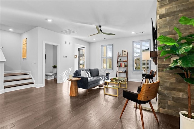 living room with ceiling fan and dark wood-type flooring