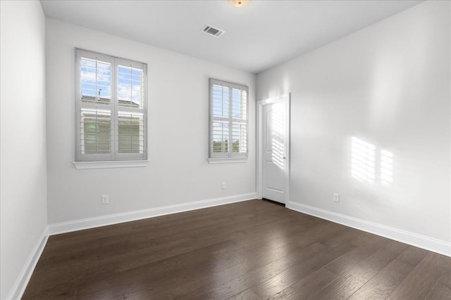 empty room with dark hardwood / wood-style flooring