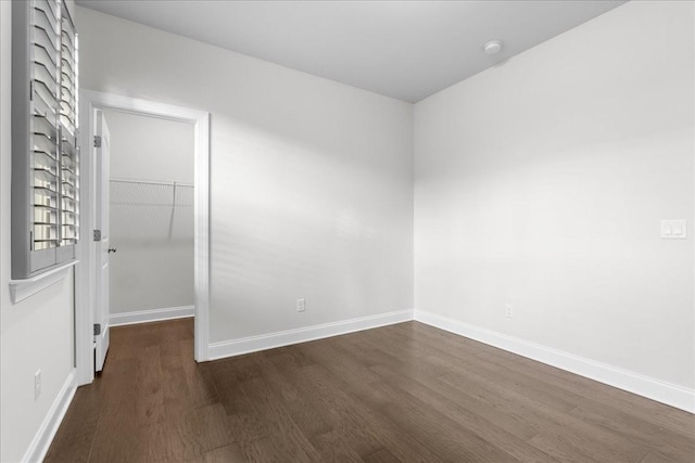 spare room with dark wood-type flooring