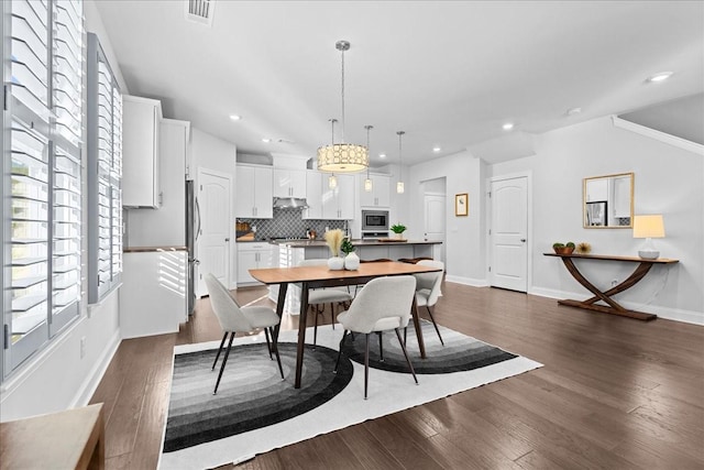 dining space with dark hardwood / wood-style floors and crown molding