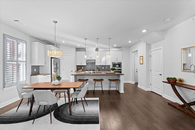 dining area with dark hardwood / wood-style floors and sink