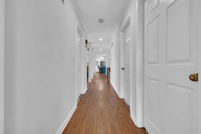 corridor featuring ornamental molding and light wood-type flooring