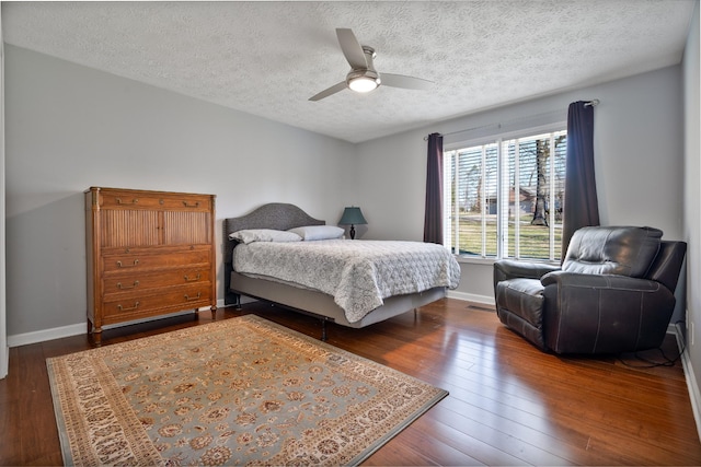 bedroom featuring ceiling fan, dark wood-type flooring, and a textured ceiling