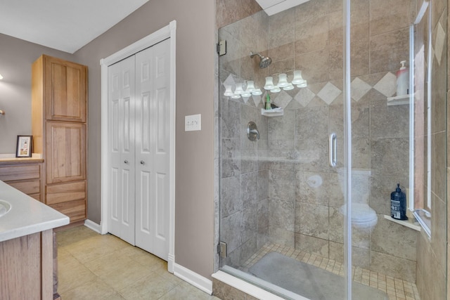 bathroom with an enclosed shower, vanity, and tile patterned floors