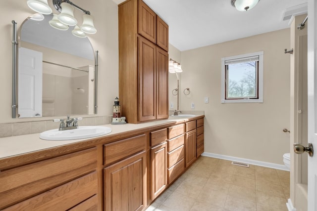 bathroom featuring toilet, vanity, and walk in shower