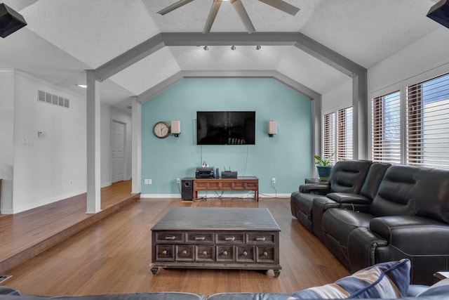 living room featuring vaulted ceiling, ceiling fan, a textured ceiling, and light hardwood / wood-style flooring