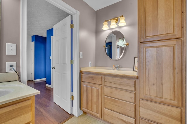 bathroom featuring a textured ceiling, hardwood / wood-style flooring, and vanity