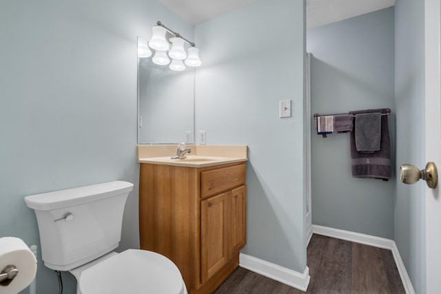 bathroom with toilet, vanity, and hardwood / wood-style floors