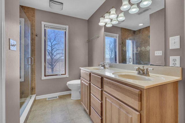 bathroom with a shower with shower door, vanity, and toilet