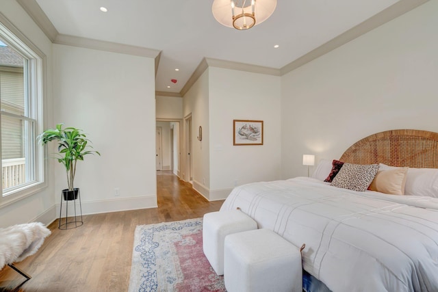 bedroom featuring crown molding and light wood-type flooring