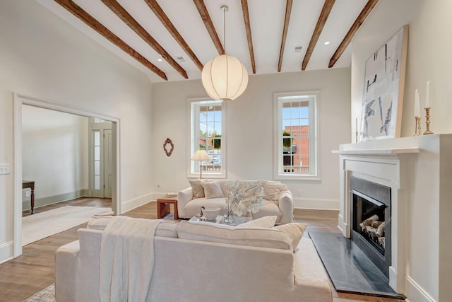 living room featuring beamed ceiling and hardwood / wood-style floors