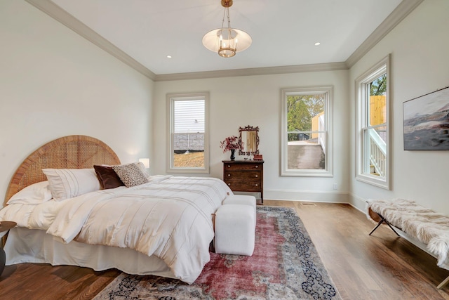 bedroom featuring multiple windows, ornamental molding, and hardwood / wood-style floors