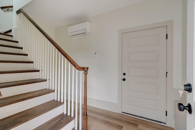 entryway with a wall mounted air conditioner and light wood-type flooring