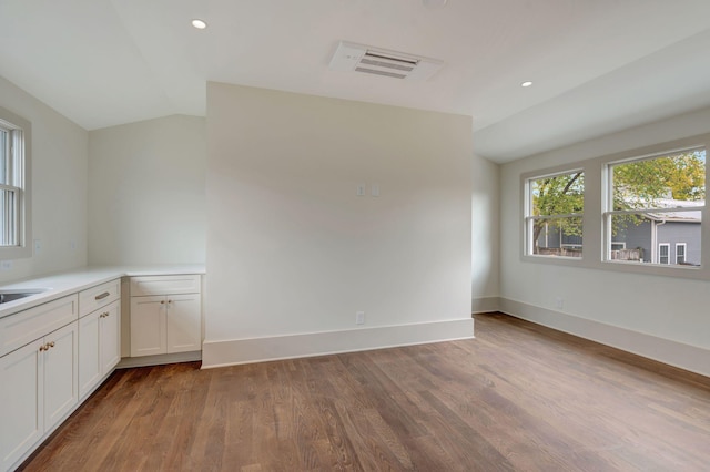 interior space featuring lofted ceiling, sink, and light hardwood / wood-style flooring