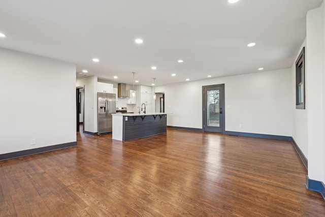 unfurnished living room with dark hardwood / wood-style floors and sink