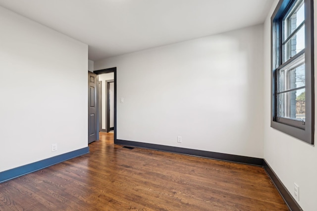 unfurnished room featuring dark hardwood / wood-style flooring