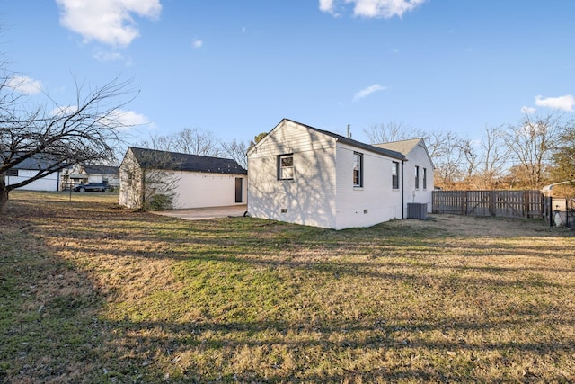 view of home's exterior with a lawn, an outdoor structure, and central air condition unit